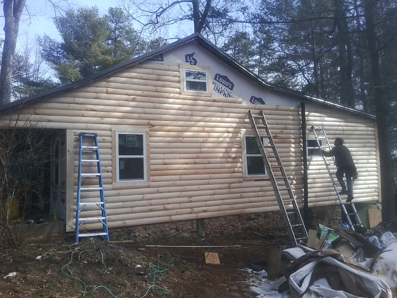Ladders set against fresh log siding during an exterior remodel in Strathmere