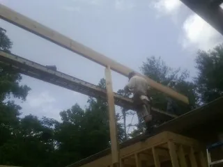 Carpenter setting a ridge beam over a new addition frame — Ice Dam Removal by Roofing Brothers in Strathmere
